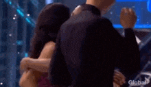 a woman in a purple dress is talking to a man in a suit on a television show .