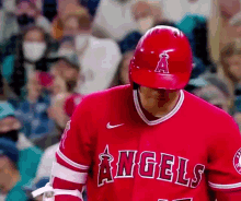 a baseball player wearing a red angels jersey and helmet .