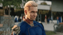a man in a blue superhero costume looks at the camera