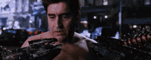 a man without a shirt is holding a mechanical arm