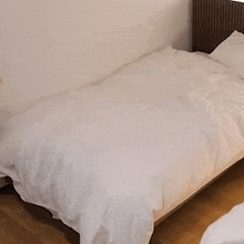 a woman in a black jacket is making a bed .