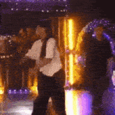a woman is dancing on a stage in a dark room .