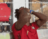 a man in a red shirt with the words you broke the no shower streak of 2256 days on the bottom
