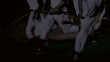 a group of people are dancing in the dark .