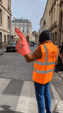 a man wearing an orange vest that says hermes unlimited on it