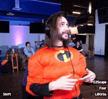 a man in a superhero costume is wearing headphones and pointing at something