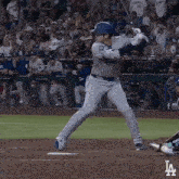 a baseball player getting ready to swing at a pitch with the la logo in the corner