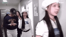 a woman wearing a polo nyc shirt is walking in a hallway