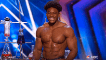a shirtless man is smiling on a stage with nbc written on the bottom