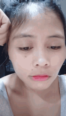 a close up of a woman 's face with a gray shirt