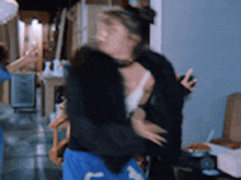 a woman in a black jacket is dancing in a hallway