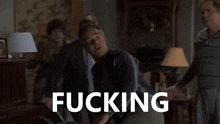a man throws a chair in a living room with queers written on the bottom