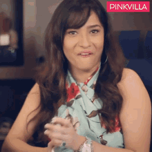 a woman is making a funny face in front of a pinkvilla sign