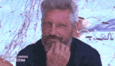a man with gray hair and a beard is smiling