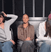a group of people are sitting in a circle with one woman sitting in the middle