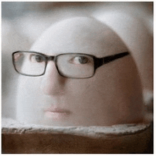 a statue of a person wearing glasses is sitting on a table .