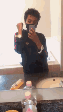 a man wearing a mask takes a selfie in front of a bathroom mirror