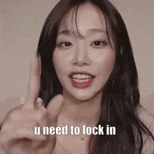 a woman is pointing at the camera with her finger and says `` u need to lock in '' .