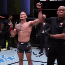 a man in a ufc shorts stands on a boxing ring