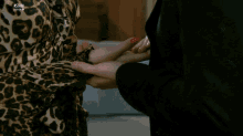 a man in a suit holds a woman 's hand in a leopard print shirt