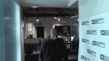 a man walks through a hallway with a sign on the wall that says ' cbs community radio ' on it
