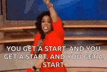 a woman in a red dress is holding a microphone and saying you get a start