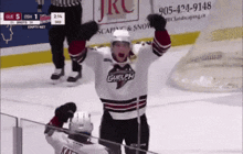 a hockey player wearing a guelph jersey celebrates his goal