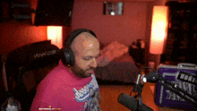 a man wearing headphones and a dodgers shirt is sitting in front of a microphone ..