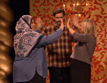a woman in a hijab gives a high five to another woman