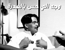 a black and white photo of a man with arabic writing on the bottom