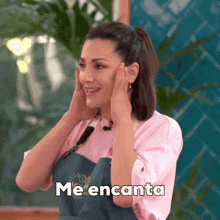 a woman wearing a pink shirt and an apron is smiling and says me encanta