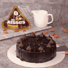 a bag of hershey 's kisses is sitting next to a chocolate cake