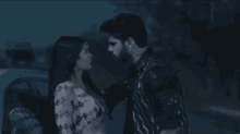 a man and a woman are looking at each other in a dark room