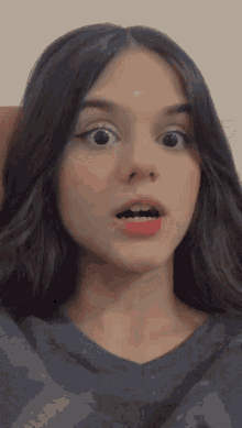 a close up of a girl 's face with her mouth open