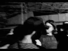a black and white photo of a group of people with one wearing a shirt that says ' nirvana '