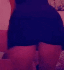 a woman in a black dress is standing on a bed in a room .