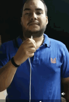 a man wearing a blue polo shirt with a logo on it
