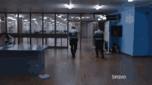 two police officers are walking through a hallway with bravo written on the bottom of the screen