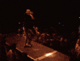 a man is laying on the ground on a stage with a crowd behind him