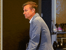 a man in a suit is standing in a dark room with the words millythecat written below him