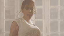 a group of women are dancing in a room with a man sitting on a chair