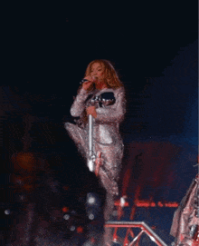a woman singing into a microphone on stage