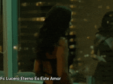 a woman in a black dress is standing in front of a window and the words lucero eterno es este amor are below her
