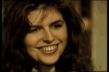 a close up of a woman 's face with a smile on her face and a lot of teeth .