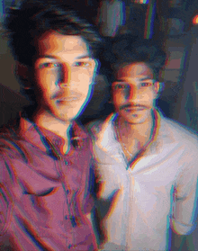 two men are standing next to each other and one has a purple shirt on