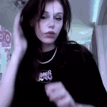 a woman wearing a black shirt and a purple necklace is dancing .