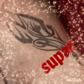 a close up of a tattoo with the word supa in red