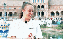 a woman wearing a white t-shirt that says ' sharks ' on the front