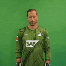 a man wearing a green shirt with the word sap on the front