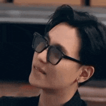 a close up of a person wearing sunglasses and making a funny face .